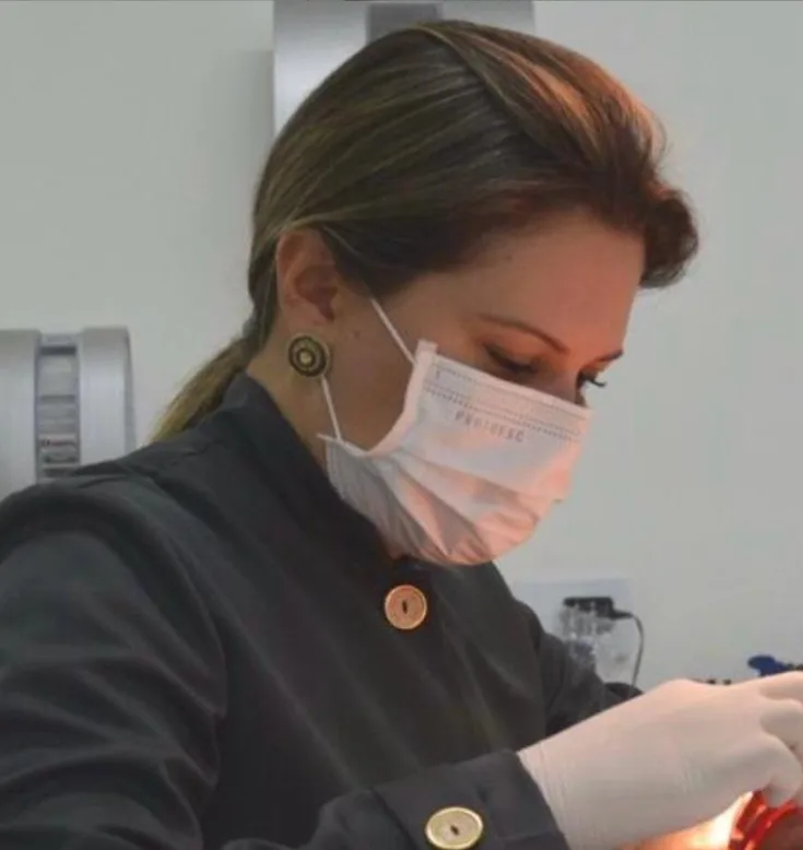 Dra. Juliana Frigério realizando um procedimento odontológico